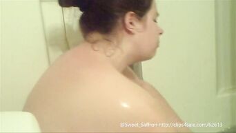 A fat woman with big tits is washing in the shower